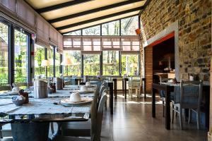 a dining room with tables and chairs and windows at Hotel Le Beau Séjour in Nassogne +30 photos