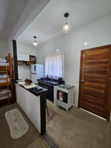 a kitchen with a sink and a stove top oven at Vila Mukaú in Porto Seguro