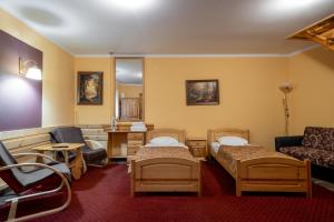 a room with two beds and a table and a couch at Pensjonat Stańczyk in Krakow