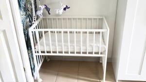 a white crib in a corner of a room at ENGI CASA VACANZE in Naples +14 photos