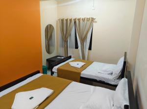 a room with two beds and a mirror at Shaktipeeth Yatrinivas in Kolhapur