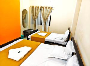 a hotel room with two beds and a mirror at Shaktipeeth Yatrinivas in Kolhapur