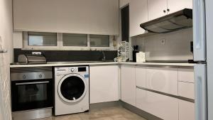 a white kitchen with a washing machine in it at Odivelas Place 1 in Odivelas