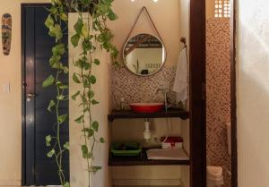 a bathroom with a sink and a mirror at Casa Aroeira Massarandupió in Entre Rios