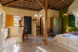 a kitchen and a bedroom with a bed in a room at Casa Aroeira Massarandupió in Entre Rios