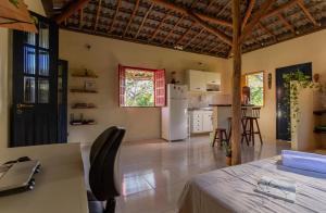 a kitchen and living room with a white refrigerator at Casa Aroeira Massarandupió in Entre Rios