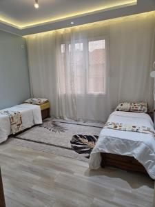 a bedroom with two beds and a window at Appartement indépendant de villa in Tipaza