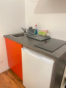 a kitchen counter with a sink and a white refrigerator at Rivellino Guesthouse app 2 in Locarno