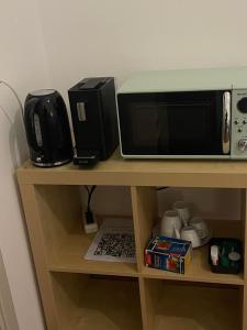 a microwave and a toaster oven on a shelf at Rivellino Guesthouse app 2 in Locarno