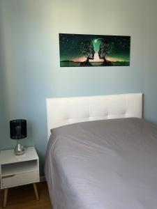 a bedroom with a bed and a night stand with a lamp at Appartement spacieux avec parking privé in Chalons en Champagne