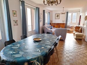a dining room with a blue table and chairs at Le Jardin d'Elise - Maison 10 personnes avec jardin - proche centre ville in Brive-la-Gaillarde