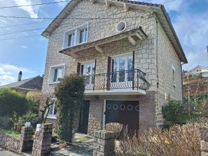 a brick house with a balcony on top of it at Le Jardin d'Elise - Maison 10 personnes avec jardin - proche centre ville in Brive-la-Gaillarde