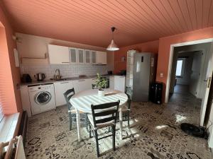 a kitchen with a table and chairs and a refrigerator at Appartement 2 chambres in Messancy +5 photos