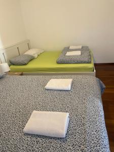 two beds in a room with towels on the floor at Rivellino Guesthouse app 1 in Locarno