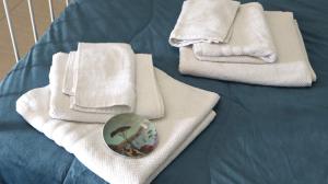 two white towels and a plate on a bed at ENGI CASA VACANZE in Naples