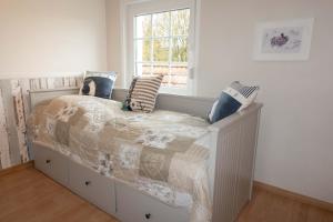 a bedroom with a bed with pillows and a window at Ferienhaus Nordsee2 in Dornum