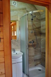 a bathroom with a shower and a sink at Domki Piękny Widok u Karola in Solina