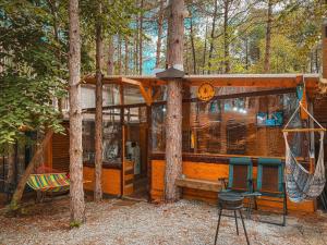 a cabin in the woods with a hammock and a swing at Бунгало Борче in Burgas