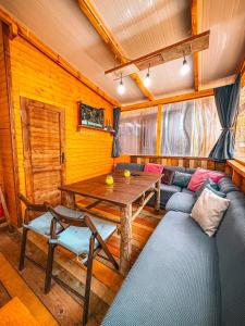 a living room with a couch and a wooden table at Бунгало Борче in Burgas
