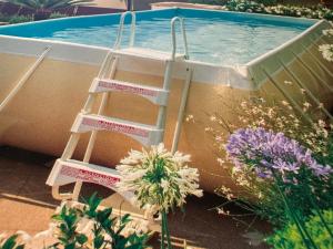 a ladder next to a swimming pool with flowers at Villalvento in Brenzone sul Garda