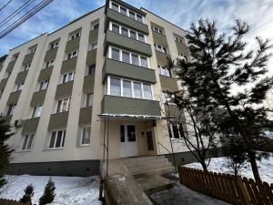 an apartment building with snow in front of it at Bliss Home 2 by RentALL in Gheorgheni