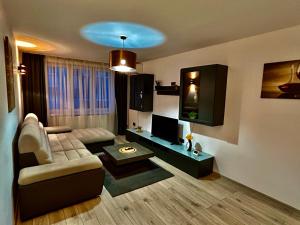 a living room with a couch and a tv at Bliss Home 2 by RentALL in Gheorgheni