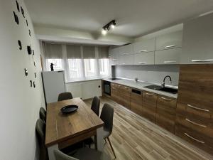 a kitchen with a wooden table and a refrigerator at Bliss Home 2 by RentALL in Gheorgheni