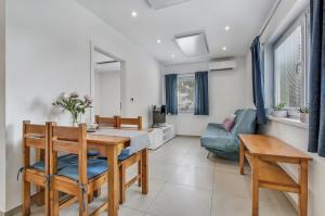 a dining room and living room with a table and a couch at Apartment MINT in Senec