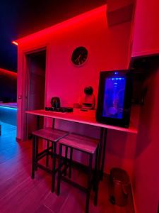 a red room with a bar with stools and a tv at Fifty shades in Bisaccia +5 photos