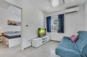 a living room with a blue couch and a television at Apartment MINT in Senec