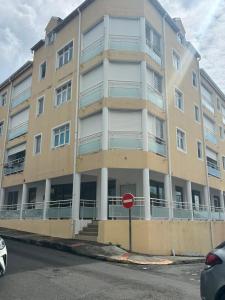 an apartment building with a stop sign in front of it at Évasion Soleil in Le Gosier
