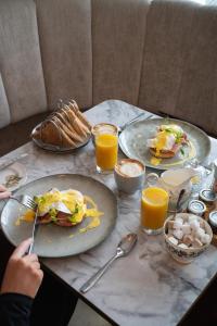 a table with plates of breakfast foods and orange juice at The Residence by Atholl Arms in Dunkeld