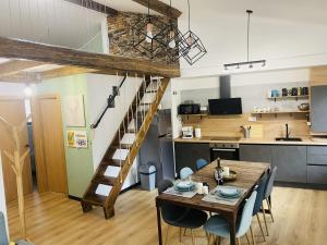 a dining room and kitchen with a wooden table and a staircase at Ático en Jaca in Jaca
