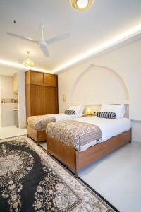 a bedroom with two beds and a ceiling fan at Theban Hills Hotel, Luxor in ‘Ezbet Abu Ḥabashi +74 photos