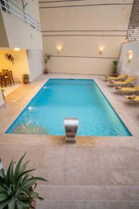 a large swimming pool with chairs in a building at Theban Hills Hotel, Luxor in ‘Ezbet Abu Ḥabashi