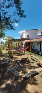 a park with a hammock and benches and a building at Cabaña, Casa de campo EL LAGUITO - Mesa de los Santos in Los Santos