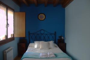 a blue bedroom with a bed with two towels on it at Casa rural Angelita in Cangas de Onís