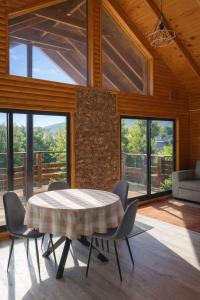 a dining room with a table and chairs and windows at Cabaña Palafito in Coelemu