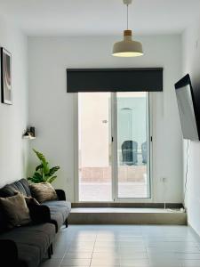 a living room with a couch and a large window at Casa Capitan Coliving Coworking Digital Nomads in San Miguel de Abona