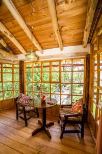 a room with a table and chairs and windows at IORANA HOTEL Urubamba in Urubamba