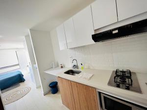 a white kitchen with a sink and a stove at Apartamento mar in Tunja