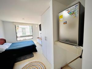 a small room with a bed and a refrigerator at Apartamento mar in Tunja