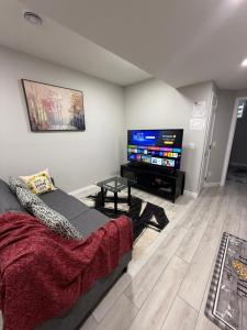a living room with a couch and a flat screen tv at Slice Of Paradise in Calgary