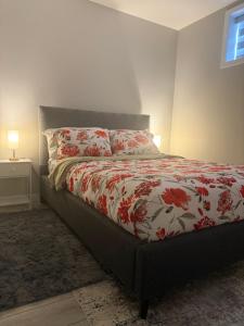 a bedroom with a bed with a red and white comforter at Slice Of Paradise in Calgary