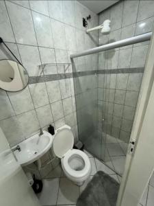 a bathroom with a toilet and a sink and a shower at Bela vista jardim camburi in Vitória