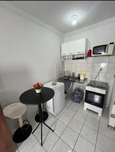 a small kitchen with a black table and a stove at Bela vista jardim camburi in Vitória
