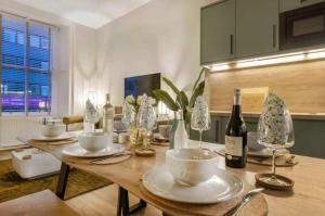 a kitchen with a wooden table with a bottle of wine at The Sauchie in Glasgow