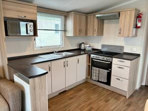 a small kitchen with a sink and a stove at Chesil View in Wyke Regis