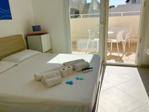 a bedroom with a bed with two towels and a balcony at Sea Rooms - Torre Pali in Torre Pali