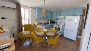 a kitchen with blue cabinets and a table and chairs at Propre Confortable Près des services in Saint-Joseph-de-Beauce